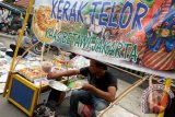 Seorang pedagang mempersiapkan makanan Kerak Telor khas Betawi di arena Pasar Wadai Ramadan 1435 Hijriah di ruas jalan Jenderal Sudirman Banjarmasin, Minggu (29/6). Makanan khas Betawi tersebut ditawarkan per satuannya dengan harga 15 ribu rupiah untuk berbahan telur ayam dan 20 ribu untuk telur bebek. Foto Antaranews Kalsel/Herry Murdy Hermawan