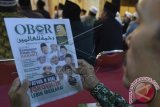 Seorang pria membaca Tabloid Obor Rahmatan Lil Alamin pada pertemuan calon presiden Jokowi dengan sejumlah kiai dan ulama Jember di Surabaya, Jawa Timur, Minggu (29/6). Tabloid Obor Rahmatan Lil Alamin tersebut dibuat sebagai media kampanye penjawab dan pembantah terhadap segala kampanye hitam yang menyerang Joko Widodo. ANTARA FOTO/Widodo S. Jusuf/ed/amawdy/14.