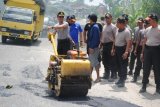 .<br />
<br />
Simalungun, 19/6 - PERBAIKI JALAN. Kapolres Simalungun AKBP Andi Syahriful Taufik menyisip jalan memperbaiki satu titik ruas jalan lintas Pematangsiantar-Raya di kawasan Desa Dame Raya untuk memberi kenyamanan pengguna jalan, Rabu<br />
Perbaikan jalan dan gotong royong membersihkan drainase tersebut merupakan rangkaian kegiatan bakti sosial menyambut Hari Bhayangkara tahun 2014. (Foto Antarasumut/Waristo)