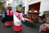 Pengamen ondel-ondel menari menghibur pengunjung wisata Kota Tua, Jakarta Barat, Minggu (8/6). Menurut PT. Pembangunan Kota Tua, kawasan wisata Kota Tua Jakarta telah didaftarkan sebagai kota warisan budaya dunia kepada UNESCO dengan tujuan membantu proses revitalisasi Kota Tua sehingga menjadi kawasan yang hidup serta menjadi pusat aktivitas masyarakat. ANTARA FOTO/Rivan Awal Lingga/wdy/14