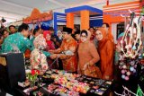 Magetan (Antara Jatim) - Pakde dan Bude Karwo beserta Ibu Hj Fatma Saifullah Yusuf meninjau pameran yang menyajikan produk unggulan kota/kabupaten se-Jawa Timur saat menghadiri puncak Peringatan Hari Koperasi ke-67 Provinsi Jawa Timur di Stadion Ki Mageti, Kabupaten Magetan, Selasa (24/6). (FOTO Humas Pemprov Jatim)


