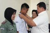 Simalungun, 31/5 - SEMATKAN TANDA PESERTA. Kepala Dinas Perhubungan, Komunikasi dan Informatika Kabupaten Simalungun Mixnon Andreas Simamora menyematkan tanda peserta kepada dua perwakilan pelajar SMA dan SMK pada  yang diadakan IJTI Sumut Komisariat Pematangsiantar-Simalungun, Sabtu. (Foto Antarasumut/Waristo)