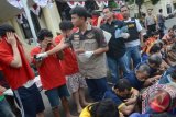 Petugas kepolisian Polrestabes Surabaya menunjukkan tersangka dan barang bukti judi bola yang ditangkap selama gelaran Piala Dunia saat gelar kasus di Mapolrestabes Surabaya, Jawa Timur, Minggu (13/7). Polrestabes Surabaya dan Polsek Jajaran, telah menangkap 117 tersangka judi bola. ANTARA FOTO/Suryanto/ss/nz/14.