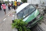 Madiun (Antara Jatim) - Sejumlah warga menyaksikan sebuah minibus dengan nomor polisi AE 1687 SG yang masuk ke saluran air setelah mengalami kecelakaan tunggal di Jalan Raya Madiun- Ponorogo, Jatim, Selasa (8/7). Minibus tersebut menabrak pembatas jalan dan masuk ke dalam saluran air, karena sopir mengantuk dan tidak bisa mengendalikan kendaraan. FOTO Fikri Yusuf/14/DK