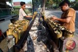 Dua pedagang memasak lemang bambu di atas tungku di kawasan Jalan Flamboyan Raya Medan, Sumut, Rabu (2/7). Makanan lemang dari bahan ketan yang dipanggang dalam tabung bambu tersebut merupakan salah satu makanan tradisional yang digemari warga untuk menu berbuka puasa yang dijual seharga Rp30 ribu per batang. ANTARA FOTO/Septianda Perdana/wdy/14.
