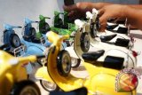 Seorang perajin menata kerajinan miniatur Vespa setelah proses pengecatan, di industri rumahan, Desa Kepulungan, Gempol, Pasuruan, Jatim, Kamis (10/7). Kerajinan tangan tersebut dijual dengan harga Rp 120 ribu - Rp 200 ribu. ANTARA FOTO/Adhitya Hendra/ss/pd/14.