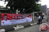 Warga melintas di depan spanduk ucapan selamat atas terpilihnya Jokowi-JK menjadi Presiden RI 2014-2019 dengan gambar Prabowo Subianto dan Hatta Rajasa di Jakarta, Rabu (23/7). KPU menetapkan Joko Widodo dan Jusuf Kalla sebagai Presiden dan Wakil Presiden terpilih periode 2014-2019 setelah memenangkan Pilpres tahun 2014 dengan mendapatkan 53,15 persen atau 70.633.576 suara melampaui pasangan Prabowo Subianto-Hatta Rajasa yang meraih 46,85 persen atau 62.262.844 suara. ANTARA FOTO/Reno Esnir/wdy/14.