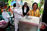 Sejumlah petugas Kelompok Panitia Pemungutan Suara (KPPS) berkostum hantu, mengarahkan seorang warga saat pemungutan suara Pilres 2014 di TPS 43 Kelurahan Moro Krembangan Kecamatan Krembangan Surabaya, Rabu (9/7). TPS unik yang digelar para petugas KPPS tersebut, bertujuan sebagai daya tarik warga agar memberikan suara pada Pilpres 2014 ini. ANTARA FOTO/Eric Ireng/wdy/14