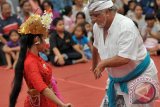 Seorang wisatawan menari bersama seniman Bali dalam pagelaran Tari Joged Bumbung di Pesta Kesenian Bali ke-36, Taman Budaya Denpasar, Kamis (3/7). Tarian tersebut dulu dipagelarkan untuk hiburan para raja namun dalam perkembangannya menjadi tari pergaulan sepasang pria dan wanita di masyarakat Bali. ANTARA FOTO/Nyoman Budhiana/ed/pd/14.