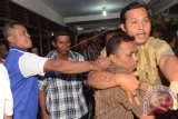 Petugas mengamankan Anggota Panwaslu Kabupaten Madiun yang diserang warga usai membubarkan acara sosialisasi Undang-Undang Nomor 6 tentang Desa di Desa Teguhan, Kab. Madiun, Jatim, Minggu (6/7). Panwaslu Kabupaten Madiun membubarkan acara tersebut karena terindikasi bermuatan politis dan menjadi ajang kampanye yang dilakukan oleh tim sukses salah satu pasangan peserta Pilpres. ANTARA FOTO/Fikri Yususf/wdy/14