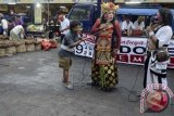 Dua seniman lawak berbincang dengan pengunjung pasar saat sosialisasi pemilihan presiden dan wakil presiden 2014 di Pasar Kreneng, Bali, Kamis (3/7). Komisi Pemilihan Umum (KPU) Kota Denpasar sengaja menyasar pasar-pasar yang menjadi pusat aktivitas masyarakat dalam mensosialisasikan pemilu untuk meningkatkan partisipasi pemilih pada Pilpres 2014. ANTARA FOTO/Wira Suryantala/wdy/14.