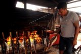 Pembuat ikan asap atau ikan asar mengasapkan ikan secara tradisional di sekitar Desa Galala, Ambon, Maluku, Minggu (3/8). Selain untuk konsumsi ikan Cakalang dan Tuna asap yang dijual dengan harga Rp 30 ribu per ekornya itu menjadi oleh-oleh khas Kota Ambon. ANTARA FOTO/Izaac Mulyawan/ss/Spt/14