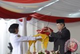 Presiden Susilo Bambang Yudhoyono (kanan) selaku Inspektur Upacara meletakkan Bendera Merah Putih ke atas baki yang dibawa anggota Pasukan Pengibar Bendera Pusaka (Paskibraka) asal SMA Negeri 1 Tahuna, Sulut, Juanna Gita Medinnas Janis (kiri) untuk dikibarkan pada Upacara Peringatan Detik-Detik Proklamasi Kemerdekaan Indonesia ke-69 Tahun 2014 di Istana Merdeka, Jakarta, Minggu (17/8). Rakyat Indonesia memperingati Hari Ulang Tahun ke-69 Kemerdekaan Republik Indonesia secara serentak di seluruh Indonesia. ANTARA FOTO/Widodo S. Jusuf/wdy/14.