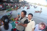 Salah seorang anggota rombongan jurnalis Pemprov Bali, Ida Bagus Ludra (kiri) saat melakukan transaksi jual beli di pasar apung, Kalimantan Selatan, beberapa waktu lalu. (FOTO ARNAWA/2014)