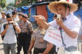 Trenggalek (Antara Jatim) - Seorang perangkat desa yang berlatar belakang aktivis pergerakan, Puryono, berorasi di pertigaan alun-alun Kota Trenggalek, Jawa Timur, Selasa (26/8), dengan pengawalan polisi. Puryono melakukan demo seorang diri saat digelarnya rapat paripurna istimewa pelantikan anggota DPRD Trenggalek periode 2014-2019. Foto Destyan Sujarwoko/14/DK