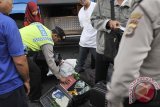 Seorang Polisi memeriksa membongkar tas milik pemudik saat operasi penertiban pendatang pada arus balik Idul Fitri 1435 H di Terminal Ubung, Denpasar, Sabtu (2/8). Operasi penertiban penduduk yang melibatkan berbagai unsur aparat tersebut untuk mencegah urbanisasi yang tidak terkontrol, pengangguran dan sekaligus untuk menekan angka kriminalitas di Pulau Dewata. ANTARA FOTO/Nyoman Budhiana/nym/2014.