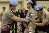 Kapolri Jenderal Pol. Sutarman (kiri) memakaikan baret biru kepada anggota Kontingen Garuda Bhayangkara yang tergabumg dalam misi pemeliharaan perdamaian PBB di Mabes Polri, Jaksel, Jumat (8/8). Kontingen Garuda Bhayangkara sebanyak 32 personel itu tergabung dalam Individual Police Officer (IPO) yang ditugaskan ke Darfur Sudan (UNAMID) dan Sudan Selatan (UNMISS) selama tiga bulan. ANTARA FOTO/Muhammad Adimaja/wdy/14.