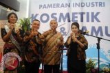 Menteri Perindustrian MS Hidayat (kedua kanan) didampingi Putri Indonesia Pariwisata 2014 Estelita Liana (kanan), Asosiasi Gabungan Pengusaha dan Obat Tradisional GP Jamu Charles Saerang (kedua kiri) dan Ketua PPA Kosmetik Putri K Wardani (kanan) menikmati jamu bersama saat menghadiri pembukaan pameran industri kosmetik dan jamu di Lobby Departemen Perindustrian, Gatot Subroto, Jakarta, Selasa (26/8). Pameran yang berlangsung hingga 29 Agustus tersebut menampilkan usaha industri kosmetik, jamu dan obat tradisional Indonesia. ANTARA FOTO/Teresia May/Asf/nz/14.