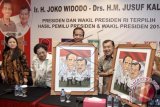 Presiden dan Wakil Presiden terpilih Joko Widodo (kedua kanan) dan Jusuf Kalla (kanan) memegang cenderamata disaksikan Ketua Umum Partai Demokrasi Indonesia Perjuangan (PDIP) Megawati Soekarnoputri (kedua kiri) serta Ketua DPP PDIP Puan Maharani (kiri) pada acara pembubaran Tim Kampanye Nasional Jokowi-JK di Posko TKN, Jakarta, Jumat (29/8). ANTARA FOTO/Muhammad Adimaja/wdy/14.