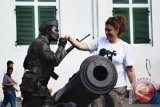 Seorang Manusia Batu mencium tangan seorang turis mancanegara di kawasan Kota Tua, Jakarta, Jumat, (1/8). Menjelang bulan September, kunjungan wisatawan mancanegara ke Indonesia diperkirakan akan mengalami peningkatan di atas 70 persen karena pada saat itu di Eropa memasuki awal musim semi atau musim panas. ANTARA FOTO/Pradita Utama/Spt/14