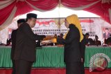 Mantan ketua DPRD Gorontalo Utara Muksi Badar menyerahkan palu sidang kepada ketua DPRD sementara Nurjanah Yusuf dari Fraksi Partai Golkar
