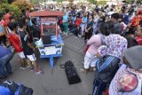 Warga mendengarkan musik dari sebuah gerobak ketoprak yang telah disulap menjadi tempat nge-DJ (disk jokey) di Bundaran HI, Jakarta, Minggu (21/9). Aksi kreatif tersebut untuk menghibur warga yang mengunjungi area car free day. ANTARA FOTO/Fanny Octavianus/wdy/14.