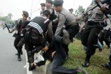 Sejumlah anggota Dit Sabhara Polda Kalbar meringkus seorang aktivis mahasiswa yang tengah berunjuk rasa di depan DPRD Provinsi Kalbar, Senin (29/9). Unjuk rasa dari sejumlah elemen mahasiswa saat pelantikan anggota DPRD Provinsi Kalbar periode 2014-2019 tersebut, berakhir ricuh dan mengakibatkan sejumlah mahasiswa terluka. ANTARA FOTO/Jessica Helena Wuysang/Asf/nz/14.