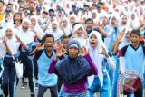 Seorang ibu dan pelajar mengikuti senam bersama pada peringatan Hari Olahraga Nasional Provinsi Kalsel 2014 di halaman sekretariat daerah Provinsi Kalsel di Banjarmasin, Jumat (19/9). Dispora Kalsel memperingati Haornas 2014 dengan menggelar kegiatan olahraga tradisional pada 19-21 September 2014. Foti Antaranews Kalsel/Herry Murdy Hermawam