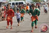 Sejumlah peserta mengikuti lomba 'Sandal Tampuruang' saat digelarnya Festival Sitti Nurbaya di kawasan Danau Cimpago Padang, Sumbar, Minggu (21/9). Lomba permainan anak menggunakan batok kelapa itu diperlombakan dalam rangka melestarikan permainan tradisional yang kini mulai punah. ANTARA FOTO/Iggoy el Fitra/wdy/14