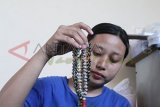 Jombang (Antara Jatim)- Pekerja menunjukan tasbih manik-manik di Desa Plumbongambang, Gudo, Jombang, Jawa Timur, Rabu (17/9). Setiap musim haji, perajin tasbih manik-manik di Desa setempat mengalami kenaikan permintaan hingga mencapai 100 persen dibanding hari biasa. Tasbih dari bahan limbah kaca itu dijual berkisar Rp10 ribu sampai Rp15 ribu.  FOTO/Syaiful Arif/14/Chan.