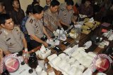 Polisi memeriksa barang bukti berupa zat kimia bahan sabu-sabu atau prekursor dan berbagai alat produksinya saat pengungkapan kasus pabrik sabu-sabu di Mapolresta Denpasar, Bali, Jumat (19/9). Polisi menangkap 4 orang tersangka pembuat sabu-sabu di 2 lokasi pabrik dan menyita lebih dari 32 Kg zat kimia berbentuk serbuk/kristal, puluhan botol cairan kimia serta berbagai peralatan produksi narkoba, yang diselundupkan dari Jakarta dan Jawa Timur. ANTARA FOTO/Nyoman Budhiana/nym/14.