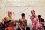 Pemain bass grup band Kotak, Chua Kotak dengan menggenakan busana pengantin Betawi tampil bersama vokalis Band Kotak Tantri (kanan) dalam resepsi pernikahan Chua di Gedung Dhanapala, komplek Departemen Keuangan, Jakarta, Sabtu (13/9). Chua Kotak resmi menikah dengan Firmansyah Mahidin Putra dan pada 7 September lalu dan menggelar resepsi dengan konsep adat Betawi. FOTO ANTARA/Teresia May