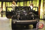 Dua model asing berpose di atas jeep Wrangler Sahara Unlimited pada peluncurannya di ajang IIMS 2014, JI Expo, Kemayoran, Jakarta, Jumat (19/9). Jeep dengan mesin 6.4L V8 HEMI ini ideal bagi para penggemar mobil 4x4 karena bertenaga jumbo dengan tampilan yang lebih garang. ANTARA FOTO/Paramayuda