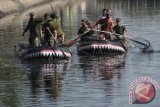 Sejumlah Prajurit TNI mengangkat sampah di sekitar kanal dengan menggunakan perahu karet pada kegiatan karya Bhakti TNI, Makassar, Sulsel, Senin (29/9). Kegiatan dalam rangka hari jadi TNI ke -69 tahun 2014 tersebut diharapkan dapat meningkatkan kesadaran masyarakat dalam hal kebersihan lingkungan. ANTARA FOTO/Dewi Fajriani/wdy/14