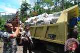 Petugas polisi dan TNI mengamankan lokasi saat memindahkan ribuan bal ganja yang dikemas dalam karung plastik dari mobil interkuler nomor polisi B 9923 HB ke mobil truk lainnya di lintasan Gunung Paro, Kecamatan Leupung, Aceh Besar, Aceh, Rabu (1/10). Mobil truk bermuatan ribuan bal paket ganja sekitar seberat 2,5 ton dalam kondisi rusak itu, awalnya ditemukan petugas polisi hutan yang sedang berpatroli , kemudian dilaporkan e anggota koramil dan polsek tedekat, sementara supir dan pemilik ganja belum berhasil ditangkap. ANTARAACEH.COM/Ampelsa/14