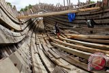 Pekerja menyelesaikan pembuatan kapal kayu nelayan di bantaran sungai Krueng Aceh, Desa Peulanggahan, Banda Aceh, Selasa (21/10). Pembuatan kapal baru di daerah itu terkendala krisis bahan baku kayu dan termasuk pulhan kapal rusak yang membutuhkan perbaikan terlantar dan sebagian lapuk akibat tertimbun lumpur sungai. ANTARAACEH.COM/Ampelsa/14