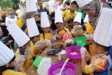 Anak-sekolah didampingi guru pembimbing membuat makanan boh roem-roem (ondel-ondel) khas Aceh saat mengikuti lomba kuliner tradisional di Taman Potroe Phang, Banda Aceh, Minggu (26/10). Lomba kuliner tradisional yang digelar Dinas Pariwisata Aceh bekerjsama dengan Bank BRI melibat sejumlah kelompok peserta dari berbagai sekolah itu, bertujuan memberikan pendidikan kepada anak menyukai makanan tradisional alami tanpa pengawet dan sekaligus cinta pangan nasional. ANTARAACEH.COM/Ampelsa/14