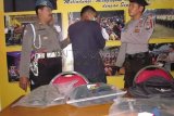 Jombang (Antara Jatim) - Tersangka pembunuhan sekeluarga di Jombang, IP (19), dengan petugas saat gelar perkara di Mapolres Jombang, Jawa Timur, Rabu (22/10). Tiga orang yang masih satu keluarga dibunuh tersangka, sementara seorang lagi dirawat di rumah sakit. Tersangka merasa sakit hati sering dituduh mencuri oleh korban. FOTO Asmaul Chusna/14/Oka. 