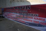 Jombang (Antara Jatim) - Warga memasang spanduk penolakan peresmian ruas jalan tol Mojokerto-Kertosono seksi I di Desa Tampingmojo, Tembelang, Jombang, Jawa Timur, Senin (13/10). Sampai saat ini sebagian warga terdampak jalan tol tersebut, menolak harga yang dipatok Panitia Pembebasan Tanah (P2T). Warga juga menolak penyelesaian masalah jual beli lahan ini melalui jalur konsinyasi. (FOTO Syaiful Arif/14/edy)