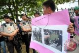 eorang aktivis Himpunan Mahasiswa Islam (HMI) Pontianak membawa poster berisi foto aksi kekerasan yang dilakukan petugas kepolisian saat berunjuk rasa di Mapolda Kalbar, Selasa (30/9). Mereka menuntut Polda Kalbar untuk bertanggung jawab atas aksi kekerasan yang dilakukan oleh petugas kepolisian terhadap para mahasiswa saat unjuk rasa di DPRD Kalbar pada Senin (29/9) kemarin, hingga mengakibatkan Ketua HMI Pontianak, Abang Basyar serta sejumlah aktivis mahasiswa lainnya terluka dan harus menjalani rawat inap di rumah sakit. ANTARA FOTO/Jessica Helena Wuysang