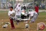 Siswa membersihkan koran bekas alas shalat Istisqo di halaman Masjid Raya Sabilal Muhtadin Banjarmasin, Selasa (14/10).  Saat ini modifikasi cuaca dengan hujan buatan tidak memungkinkan dilakukan di Kalimantan Selatan karena kurangnya kadar air di gumpalan awan. Foto Antaranews Kalsel/Herry Murdy Hermawan