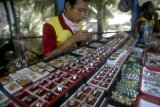 Sidoarjo (Antara Jatim) - Pedagang menata cincin batu akik di kios miliknya di Pasar Larangan, Sidoarjo, Jawa Timur, Selasa (28/10). Batu akik yang dijual dengan rentang harga 25 ribu hingga 500 ribu rupiah ini kian menjadi tren perhiasan di kalangan anak muda dan orang-orang tua yang mengakibatkan permintaan dan harga jual batu akik terus mengalami peningkatan. Foto Suryanto/14.