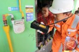 Petugas tekhnisi Perusahaan Gas Negara (PGN) Cirebon disaksikan seorang ibu rumah tangga memeriksa tingkat keamanan meter gas yang rumahnya sudah dialiri Gas Bumi milik Perusahaan Gas Negara di Harjamukti, Cirebon, Jawa Barat, Selasa (7/10). PGN bekerjasama dengan Kementerian ESDM dan Pemkot Cirebon telah berhasil mengalirkan gas bumi kepada 4000 rumah, langkah tersebut dilakukan untuk mempercepat konversi energi dari Bahan Bakar Minyak (BBM) ke Gas Bumi. ANTARA FOTO/Muhammad Iqbal/wdy/14.