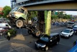 Sebuah truk bermuatan tanah tersangkut di jembatan penyeberangan orang (JPO) di Jalan Sudirman, Tangerang, Banten, Jumat (10/10). Tersangkutnya truk itu akibat lupa mengkunci hidroli yang mengakibatkan kemacetan pada ruas jalan tersebut. ANTARA FOTO/Lucky R./Rei/14.