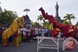 Dua seniman keturunan Tionghoa menampilkan atraksi Barongsai saat Upacara Gema Perdamaian XII di Monumen Bajra Sandhi Renon Denpasar, Bali, Sabtu (11/10).  Kegiatan tahunan itu diikuti oleh ribuan peserta dari masyarakat lintas agama untuk doa bersama di tengah situasi bangsa dan kondisi di berbagai belahan dunia masih banyak terdapat konflik. ANTARA FOTO/Wira Suryantala/wra/14 