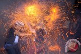 Dua pemuda saling serang dengan api dari sabut kelapa dalam tradisi Mesiat Geni atau perang api di Desa Tuban, Kabupaten Badung, Bali, Rabu(8/10) malam. Tradisi tahunan tersebut merupakan rangkaian persembahyangan di bulan purnama untuk keharmonisan sekaligus memupuk persaudaraan.  ANTARA FOTO/Wira Suryantala/i018/14.
