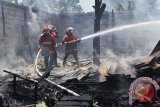 Petugas Badan Penanggulangan Bencana Daerah (BPBD) Denpasar memadamkan api yang menghanguskan sebuah gudang kayu di Denpasar, Bali, Senin (3/11). Petugas baru berhasil menguasai api setelah mengerahkan 4 unit mobil pemadam karena api menjalar sangat cepat dan sempat membuat kepanikan warga sekitarnya. ANTARA FOTO/Nyoman Budhiana/i018/2014.