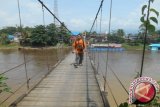 Seorang warga sedang melintas di di Jembatan Gantung Merdeka, di Kecamatan Tabang, Kutai Kartanegara(M.Ghofar/ANTARA Kaltim)