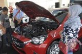 Dua pengunjung mengamati fitur mobil All New Mazda2 varian V yaitu salah satu mobil mewah yang baru diluncurkan dengan teknologi yang mendukung keselamatan pengendara, di sebuah dealer di Denpasar, Bali, Jumat (7/11). Sejumlah perusahaan otomotif akhir-akhir ini berlomba mengembangkan pasar di Pulau Dewata dengan menawarkan berbagai varian mobil beserta fitur teknologi canggih menyusul bergairahnya pasar otomotif di daerah pariwisata itu. ANTARA FOTO/Nyoman Budhiana/i018/14.