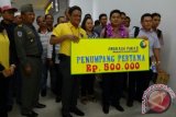 PT Angkasa Pura II cabang Bandara Supadio Pontianak resmi menggunakan terminal kedatangan penumpang yang baru pada Senin (10/11) ini. Budi Matius, penumpang perdana yang menggunakan terminal penumpang baru bandara Supadio mendapatkan kalungan bunga dan hadiah uang Rp 500 ribu. Ia mengatakan cukup kaget atas sambutan yang diberikan oleh PT Angkasa Pura. Pria asal Ketapang ini menyatakan bangga melihat kondisi terminal kedatangan penumpang yang baru dan cukup megah ini. Foto Antara Kalbar/Rendra Oxtora
